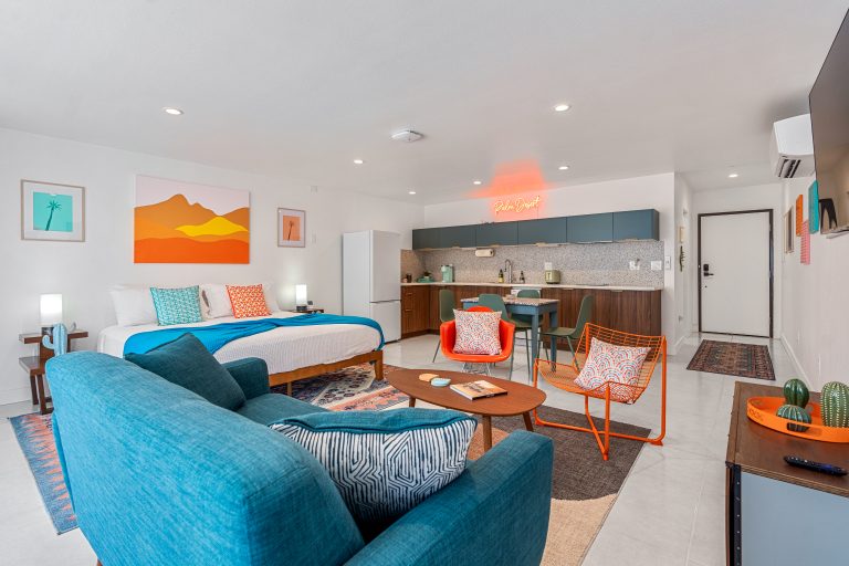 Blue Condo studio with king bed, blue sofa and desert art