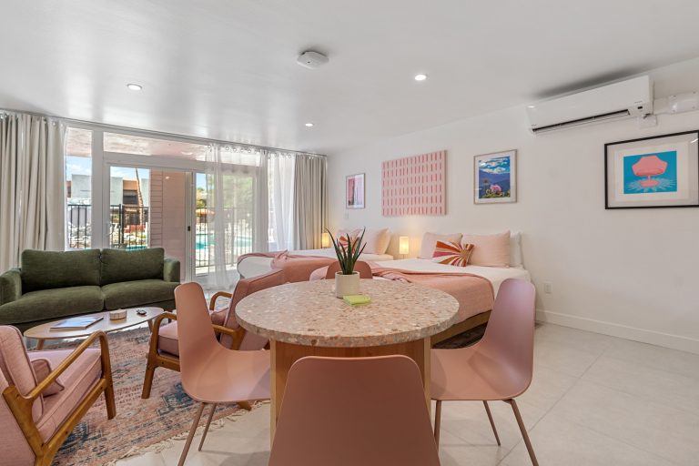 Pink Condo dining table with green sofa and retro art