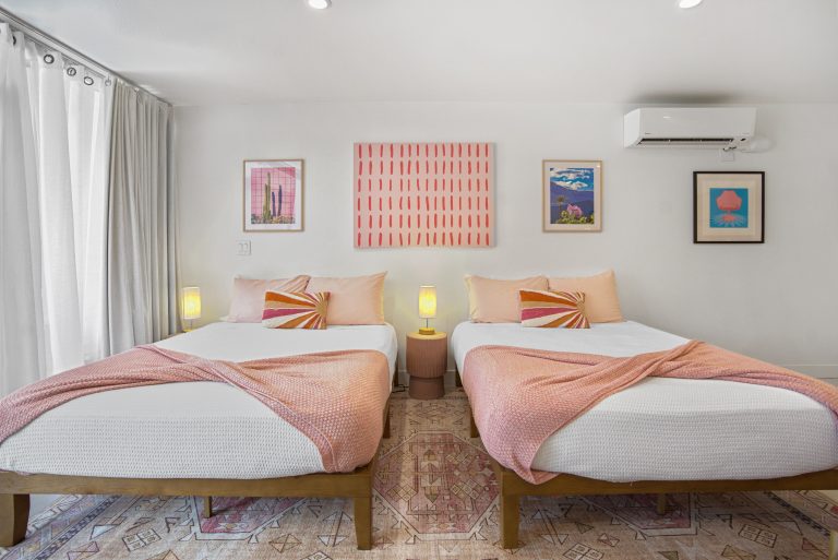 Pink Condo bedroom with two queen beds and colorful art