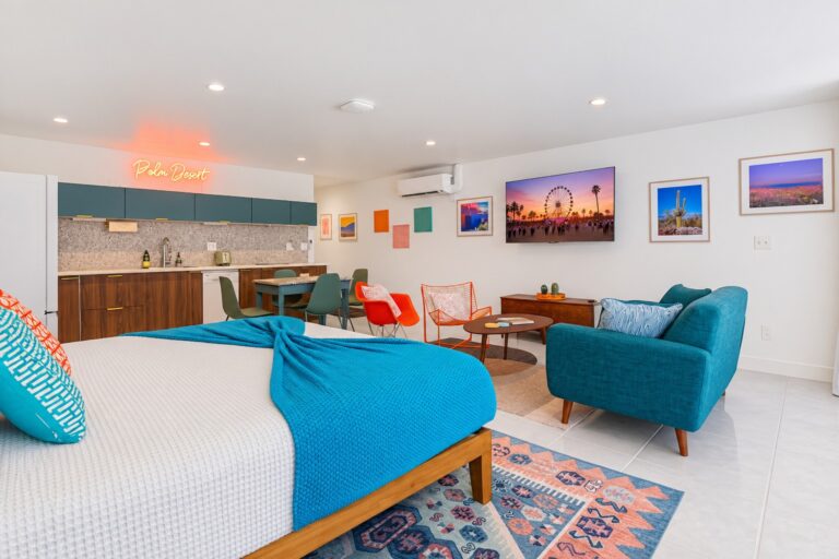 Blue condo king bed, living area and kitchen