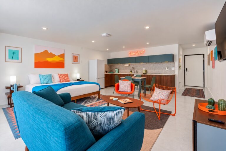 Blue condo living room with teal sofa and king bed