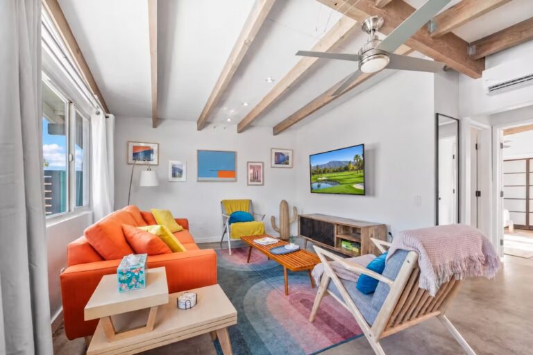 Mid-century house living room with orange sofa and wood beam ceiling