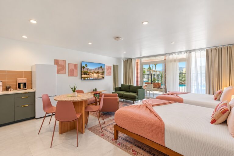 Pink condo open studio with two queen beds and sliding door to the patio