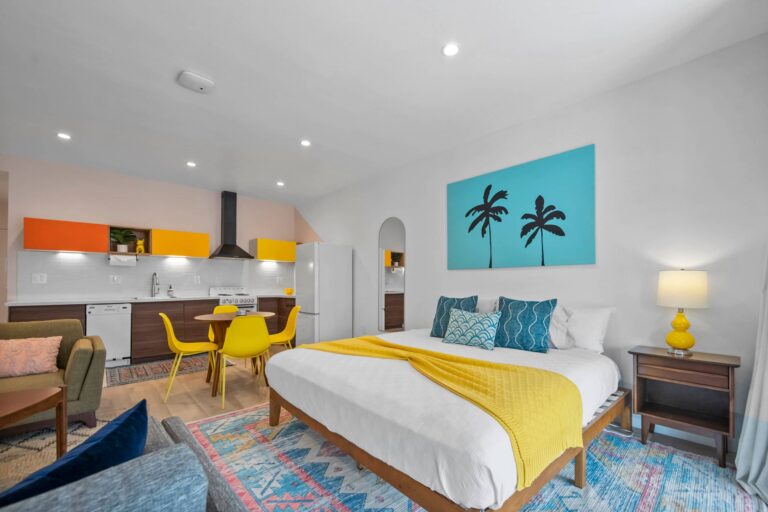 Yellow condo king bed with palm tree art