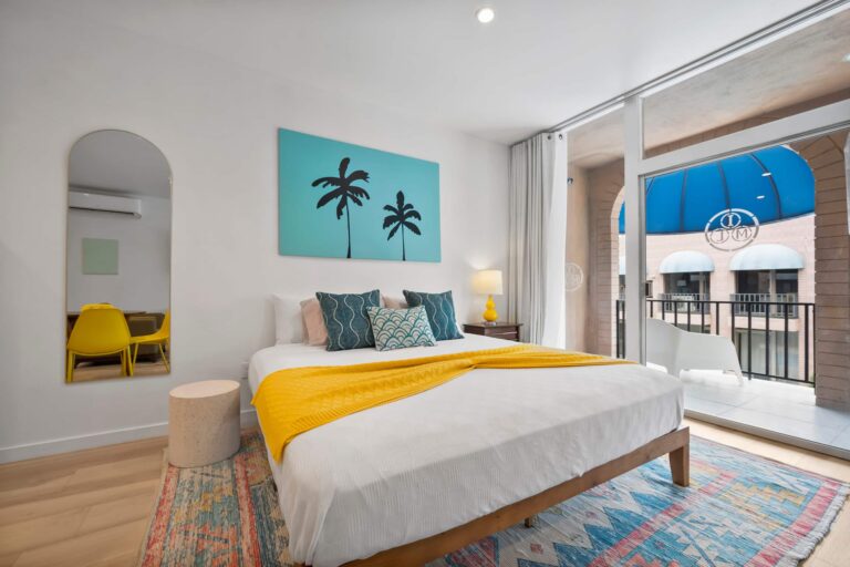 Yellow condo king bed by the balcony