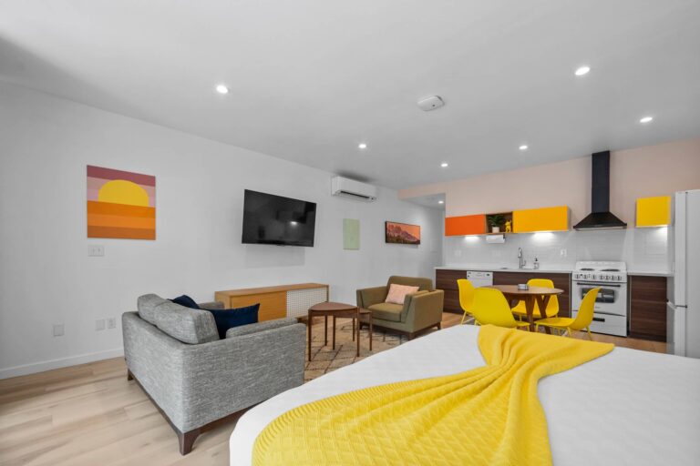 Yellow condo living area with smart TV and king bed